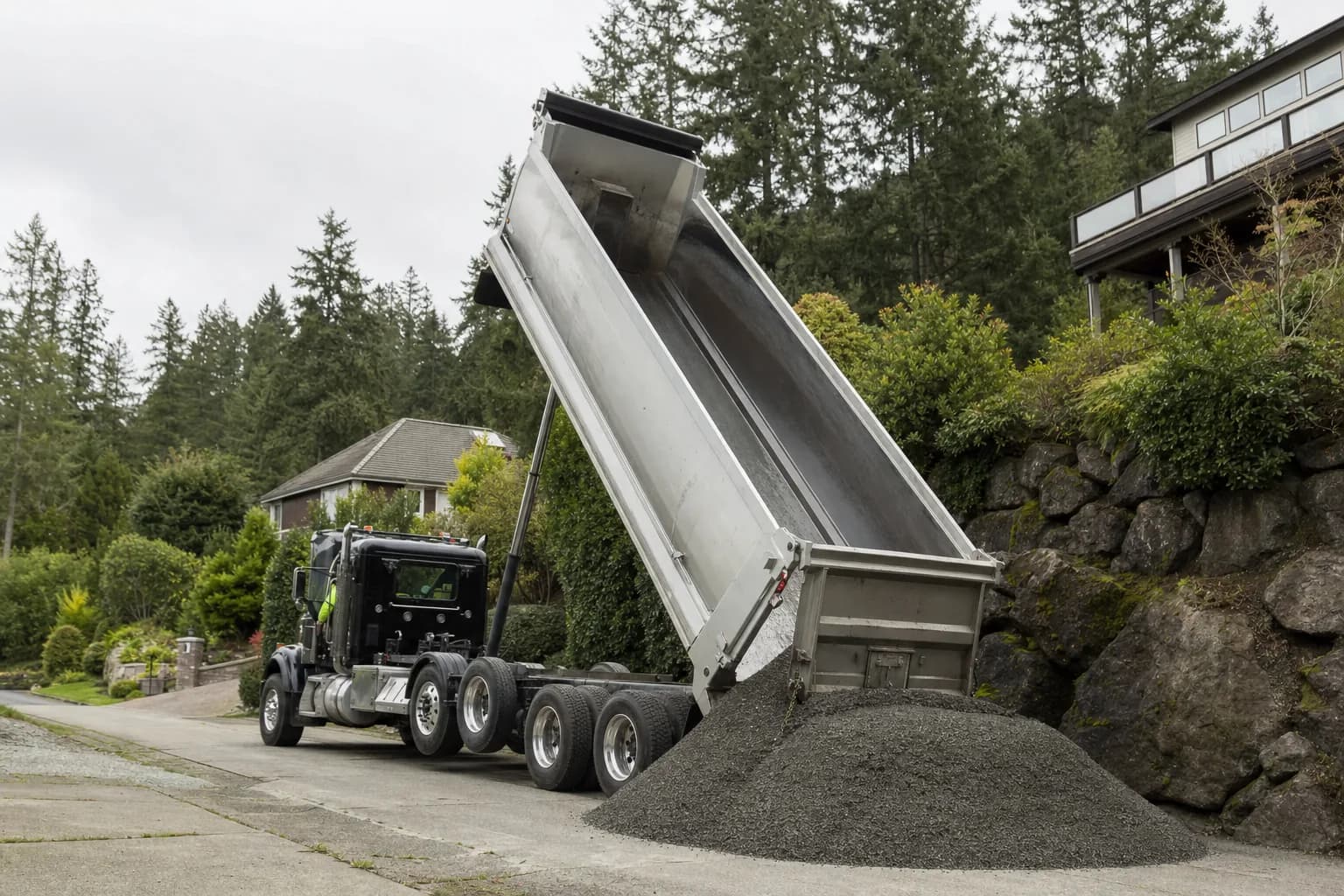 Dump truck delivering gravel to a residential property